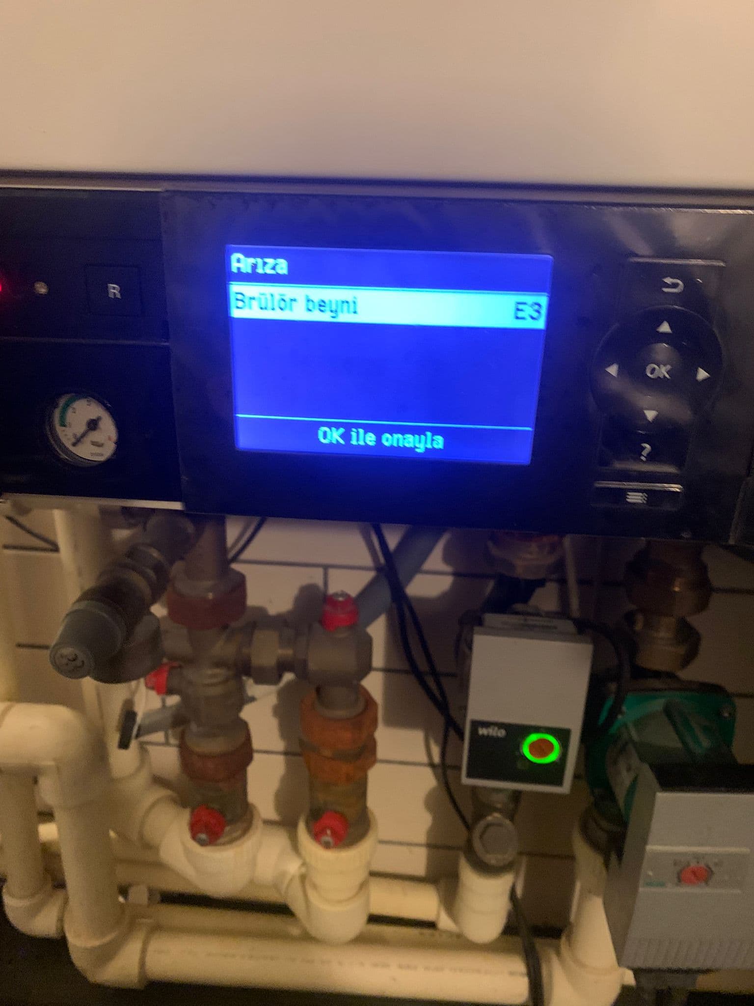 Control panel showing an E3 error message on a blue screen above mechanical plumbing.