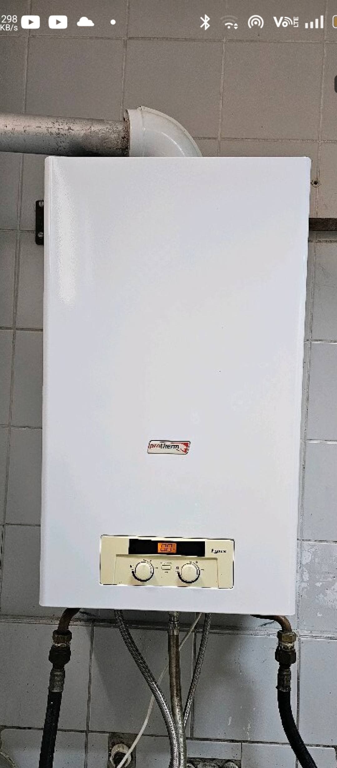 White Protherm Lynx gas boiler mounted on a tiled wall with digital display and knobs.