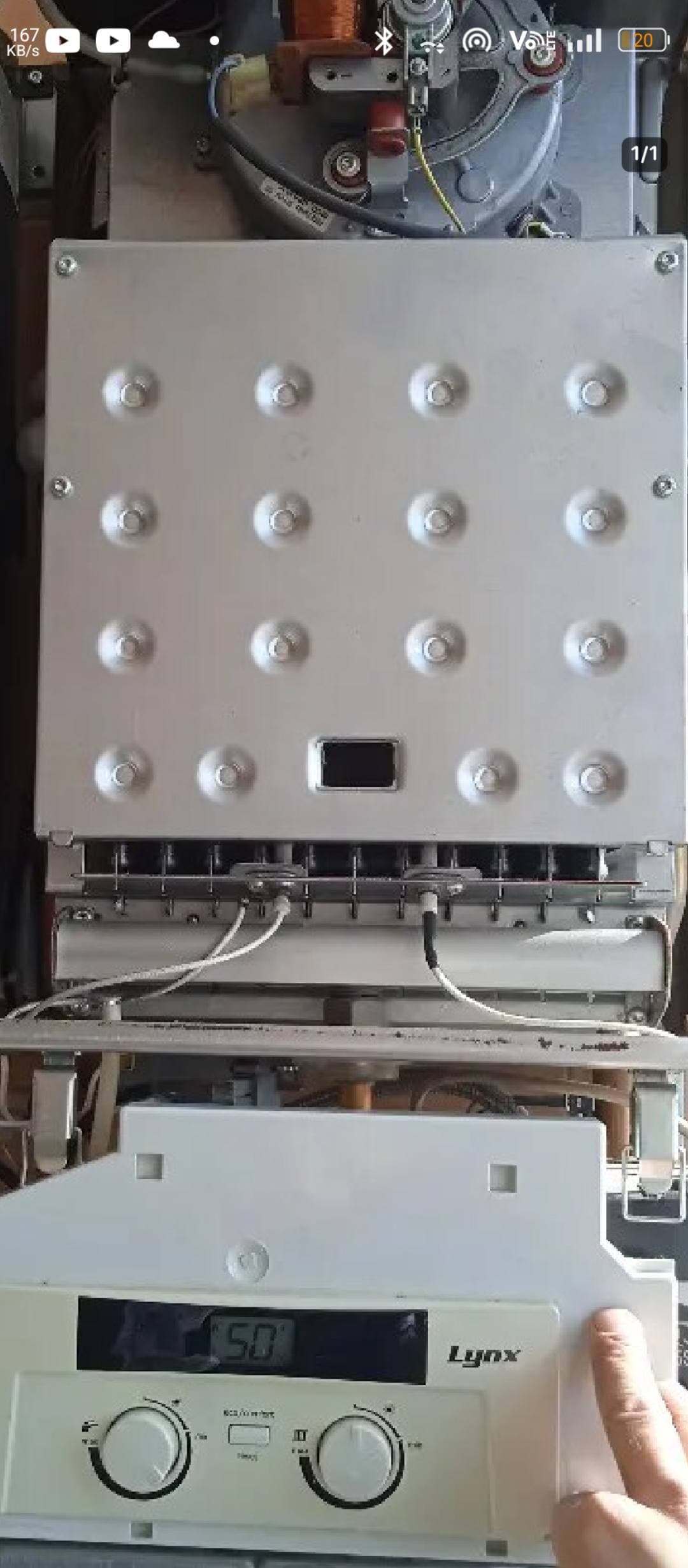 Exposed internal components of a Lynx gas boiler with metal panel and digital control display.