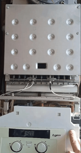 Exposed internal components of a Lynx gas boiler including burner assembly and digital control panel.